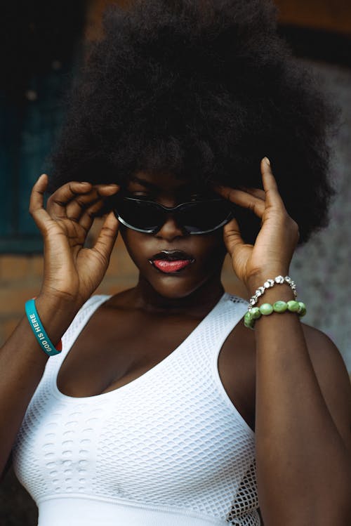 Photo of a Young Woman Wearing a White Top and Sunglasses 