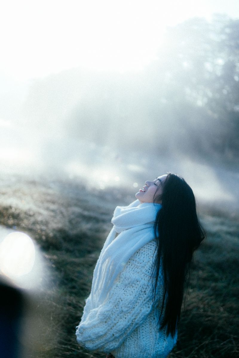 Woman in cozy sweater and scarf in sunlight