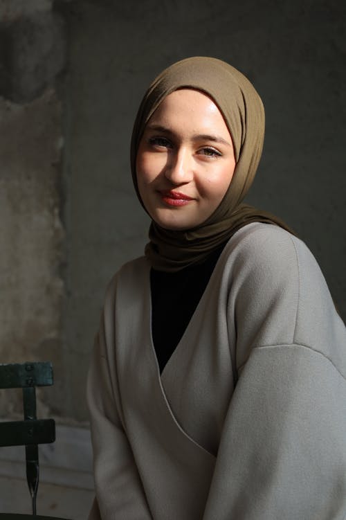 A woman in a hijab sitting on a chair