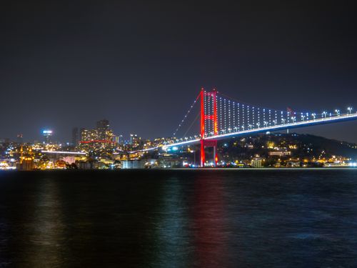 Free Dazzling night view of the illuminated Bosphorus Bridge in Istanbul over the water. Stock Photo