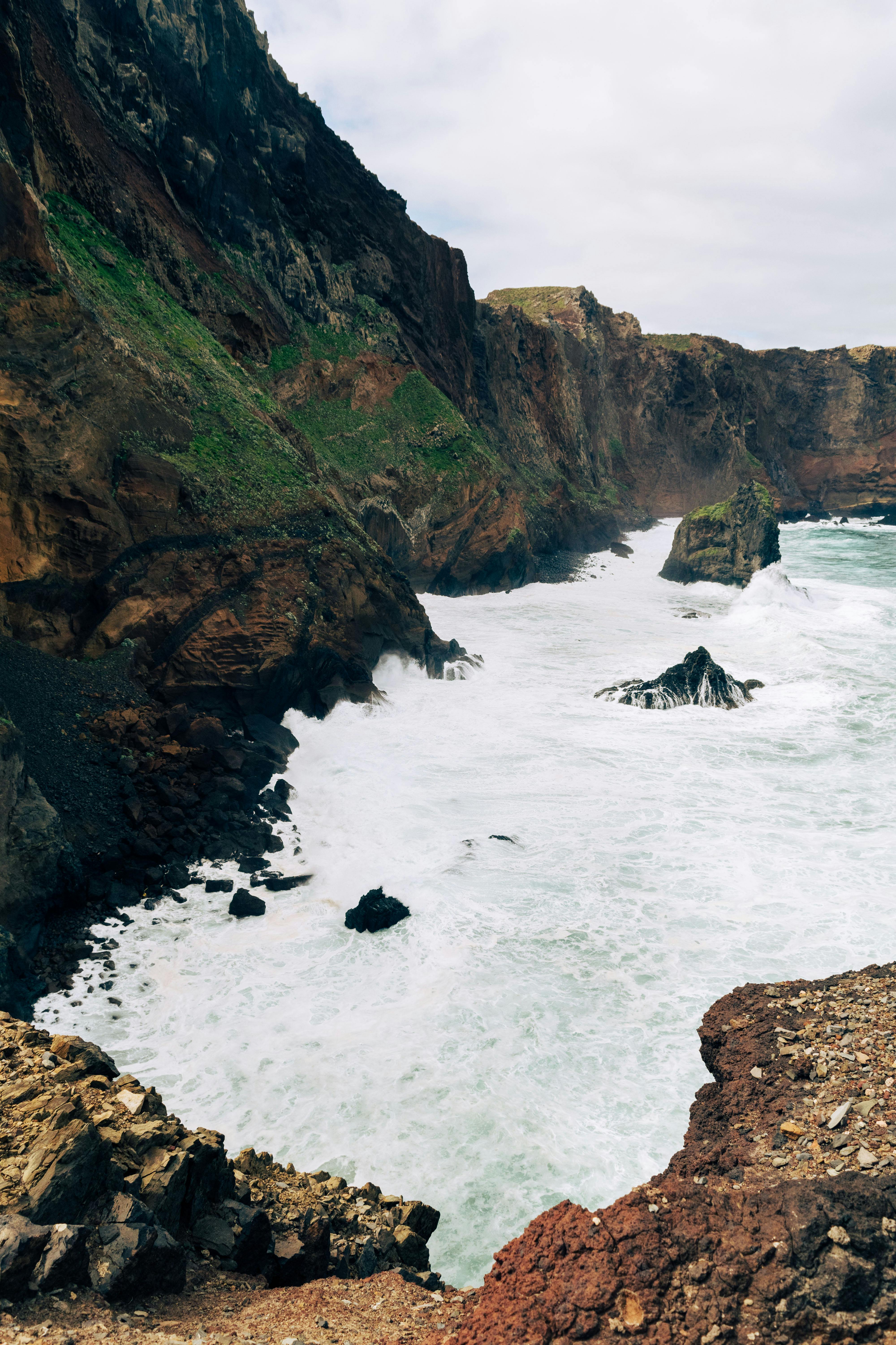 Breathtaking coastal scenery with rugged cliffs and rolling waves in Madeira, Portugal.