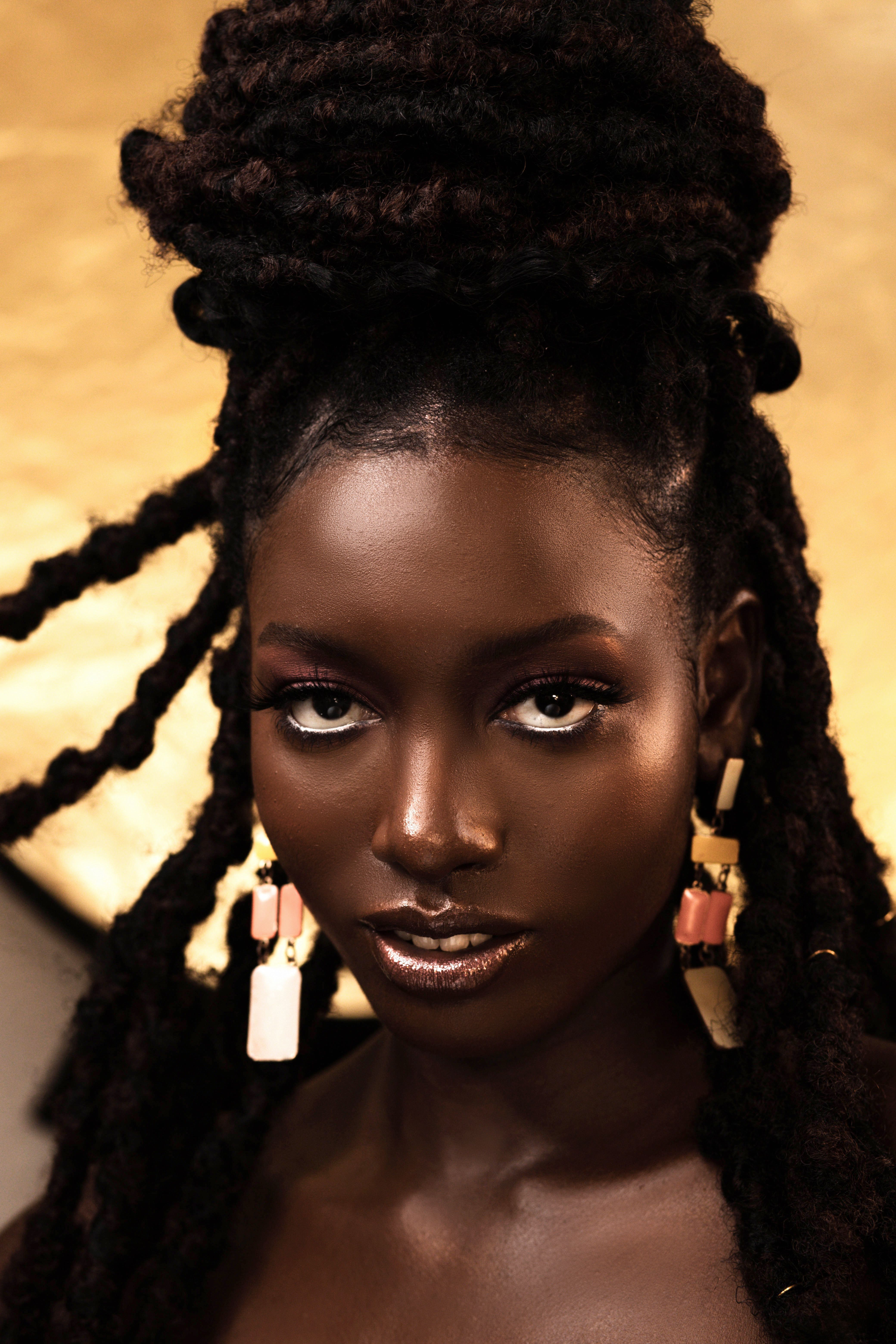 A beautiful black woman with dreadlocks and earrings · Free Stock Photo