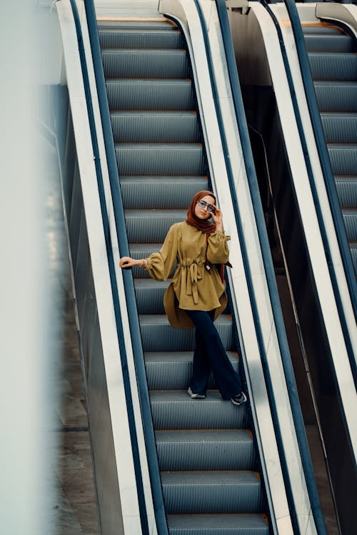 Young Woman Standing on an Escalator 