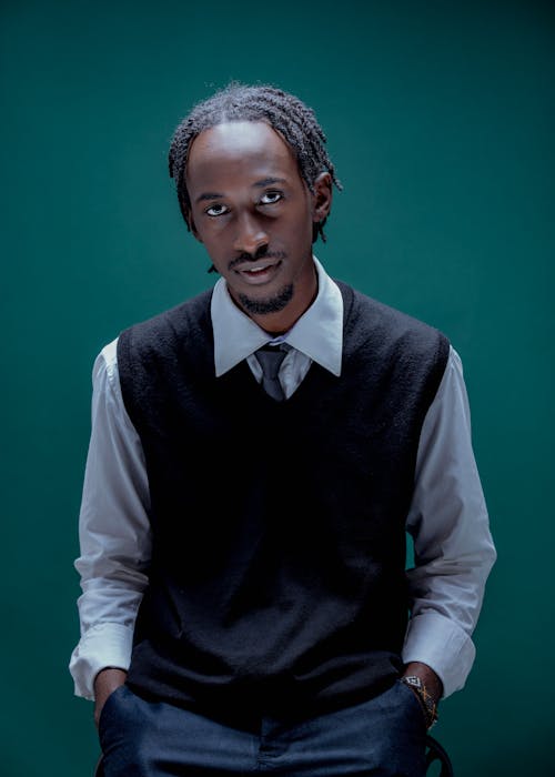 Studio Shot of an Elegant Man Sitting with Hands in Pockets 