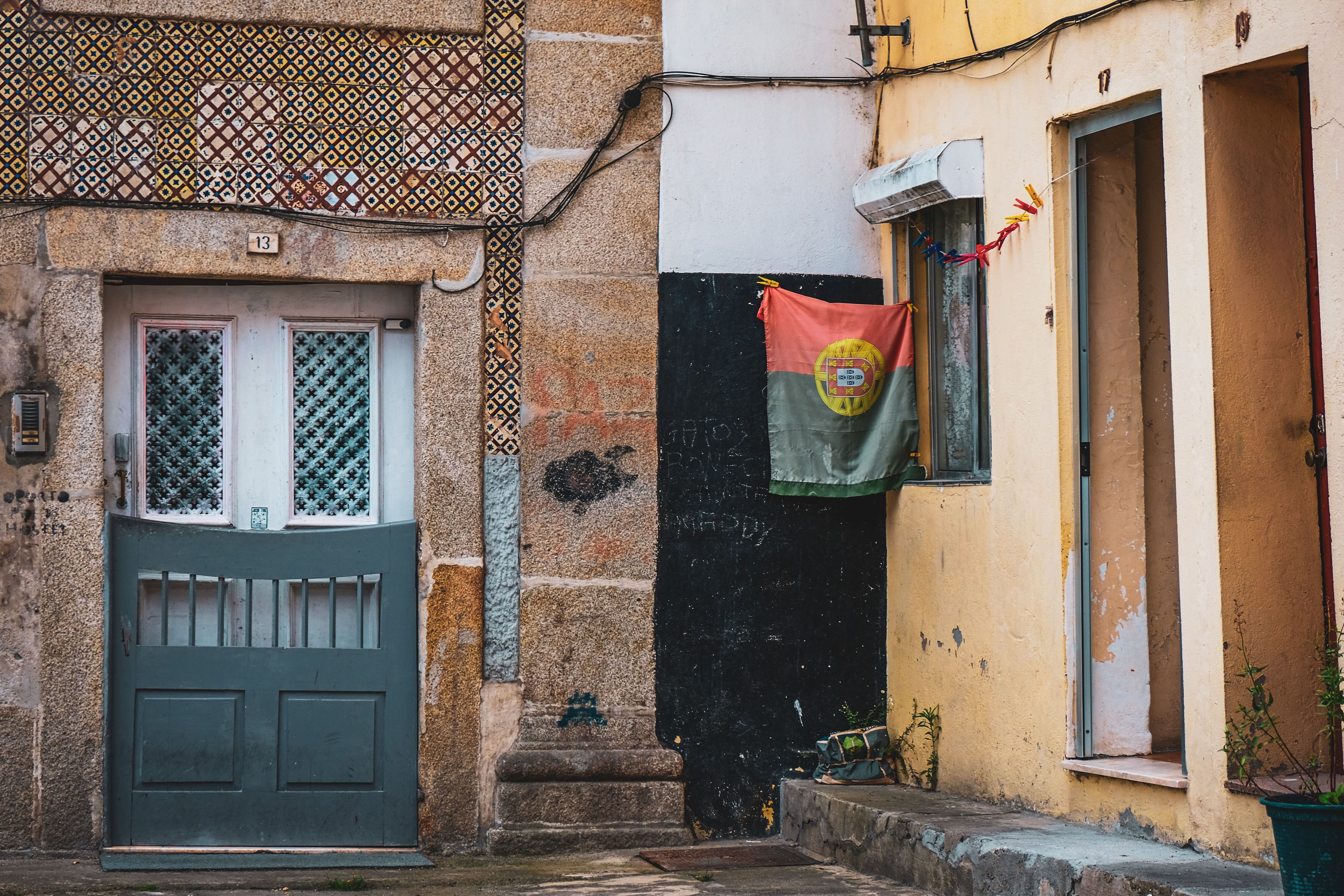 Vibrant urban street scene in Porto, showcasing traditional Portuguese architecture with a flag.