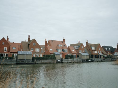 A row of houses on the water with a cloudy sky