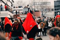 Festive parade in Leonberg, Germany featuring traditional costumes and colorful masks.