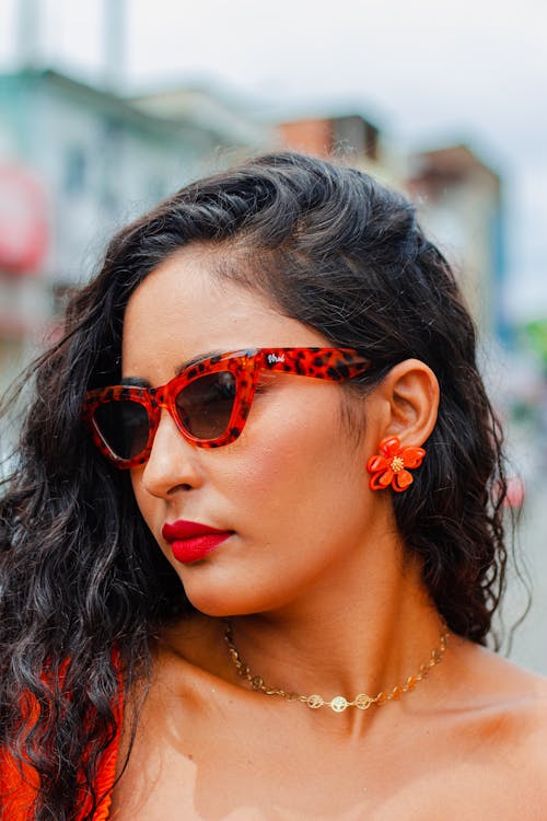 A woman wearing red lipstick and sunglasses