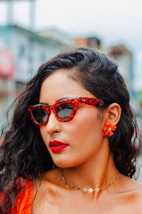 Photo of a Young Brunette Wearing a Red Lipstick and Red Sunglasses 