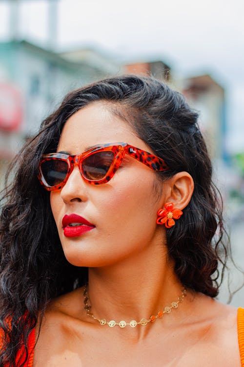 Photo of a Young Brunette Wearing a Red Lipstick and Sunglasses