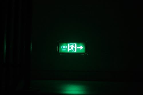 A green light on a wall in a dark room