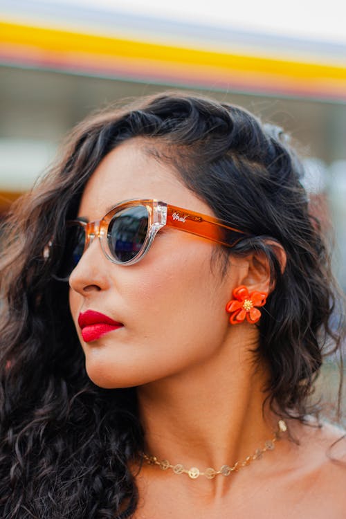 Photo of a Young Brunette Wearing a Red Lipstick and Sunglasses