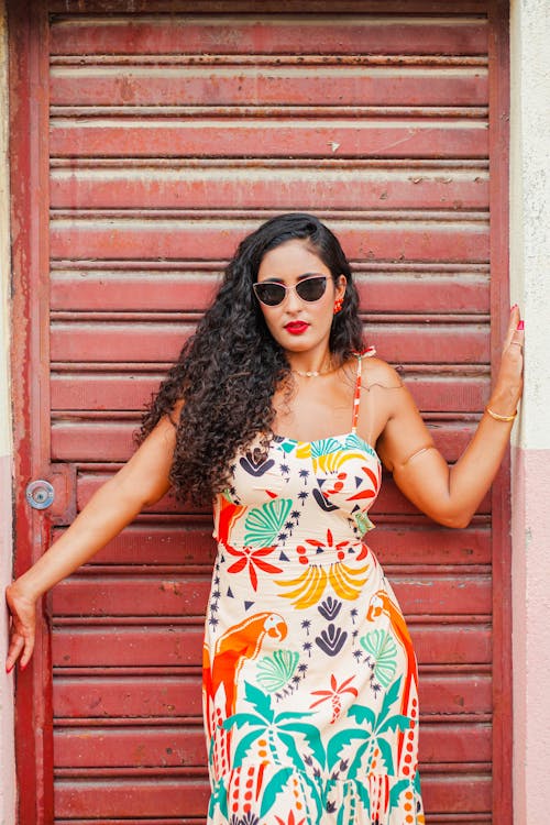 Photo of a Young Brunette Wearing a Dress, Red Lipstick and Sunglasses