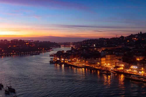 Free A breathtaking twilight view of Porto, Portugal's illuminated riverside along the Douro River. Stock Photo