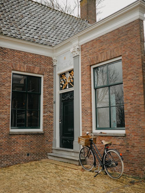 A bicycle parked outside a brick house
