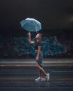 时尚的女人在雨伞下享受涂鸦背景