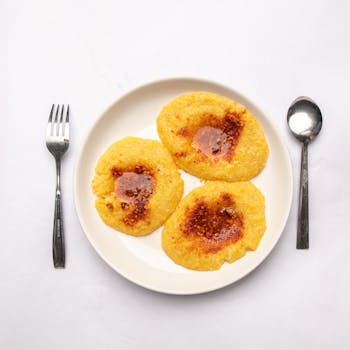 Discover a traditional Nigerian dish in an artistic flat lay with cutlery on a white background.