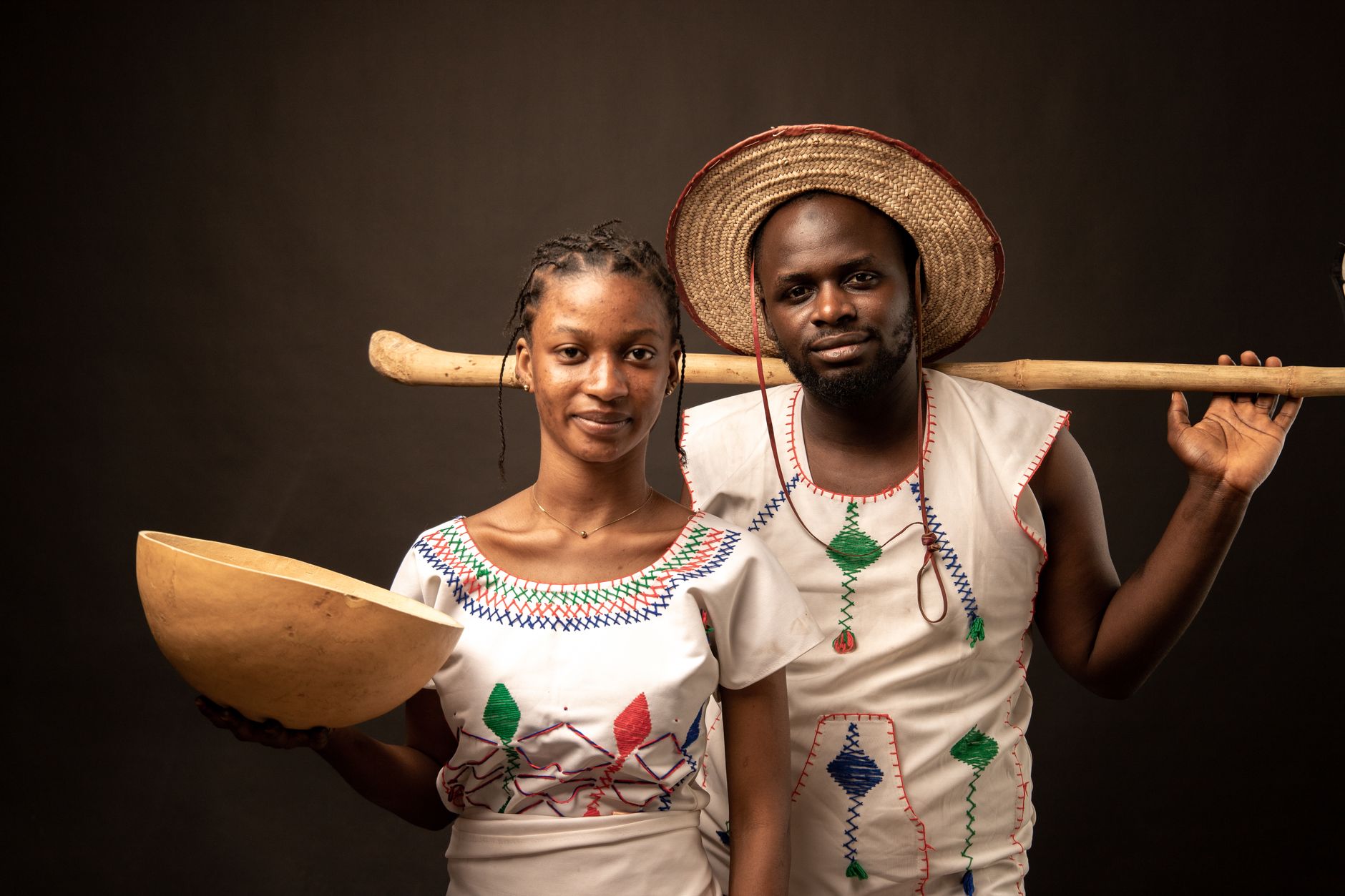A portrait of a man and woman in traditional Nigerian attire with cultural elements.