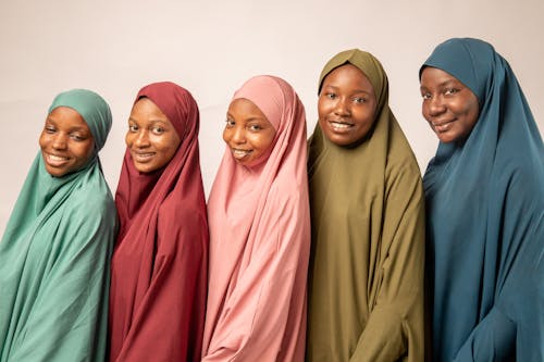 Five muslim women in hijabs smiling for the camera