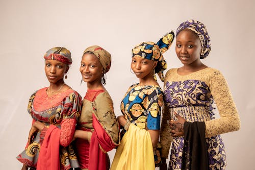 Four women in traditional african clothing pose for a photo