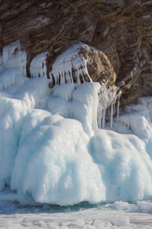 Free Intricate ice formations cascading over a rocky cliff in a winter scene. Stock Photo