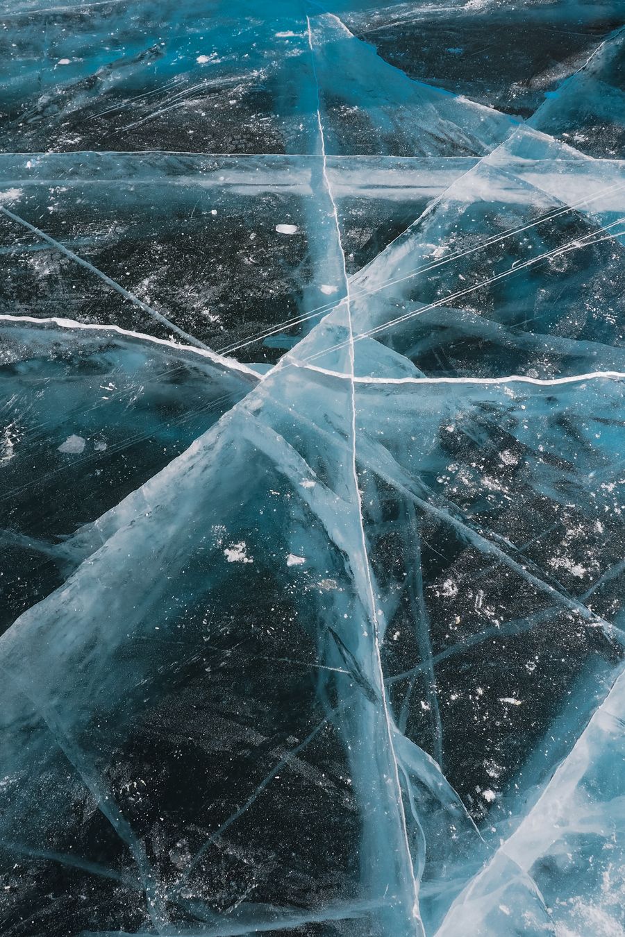 Cracks fanning across clear lake ice — photo by Nadin Sh on Pexels