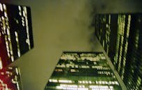 在多云的夜空下，从低角度戏剧性地拍摄多伦多摩天大楼，展现了城市的灯光