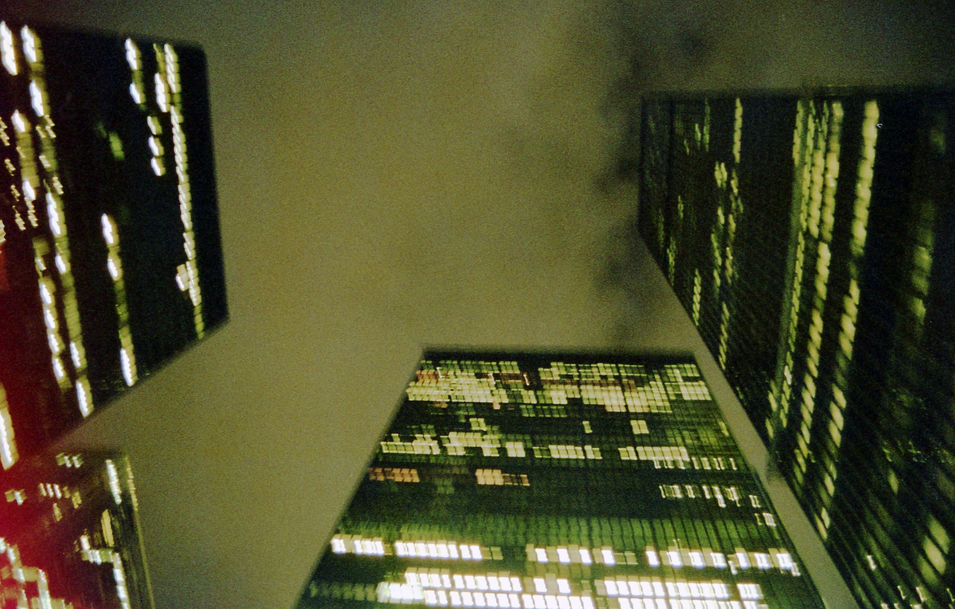 Dramatic low angle shot of Toronto skyscrapers under a cloudy night sky, showcasing city lights.