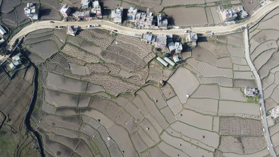 Ultimate Kathmandu: Everest Flight by Plane or Helicopter Landing Tour Review 2026 - Drone capture of intricate terraced fields and village roads in Panauti, Nepal.