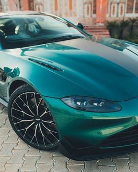 Elegant green sports car showcased in New Delhi, India.