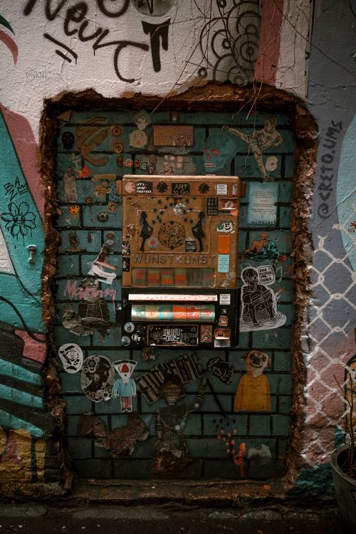 Free Vibrant urban wall art and stickers encircle a unique vending machine in Berlin. Stock Photo