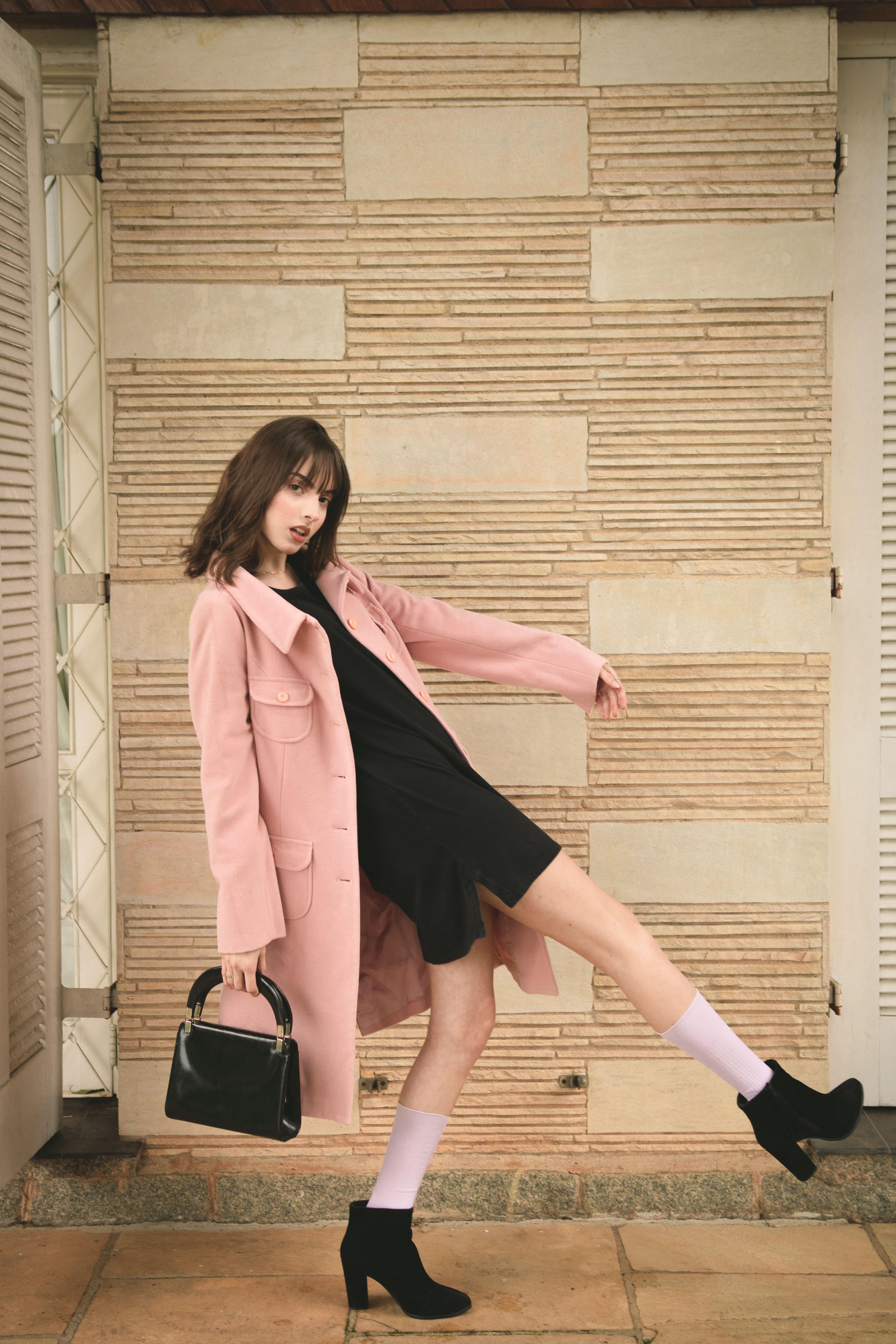 Model in a long coat photographed on the city square