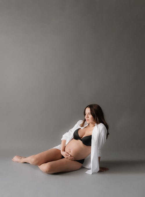 Pregnant Model Sitting in Shirt and Bra