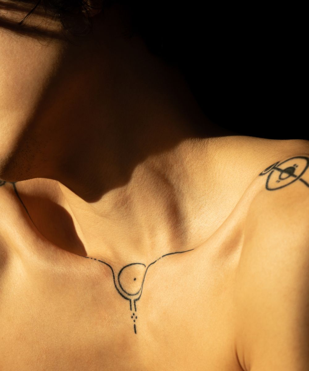 Tatuaggio fineline a linee sottili sulla pelle, fotografato in luce naturale