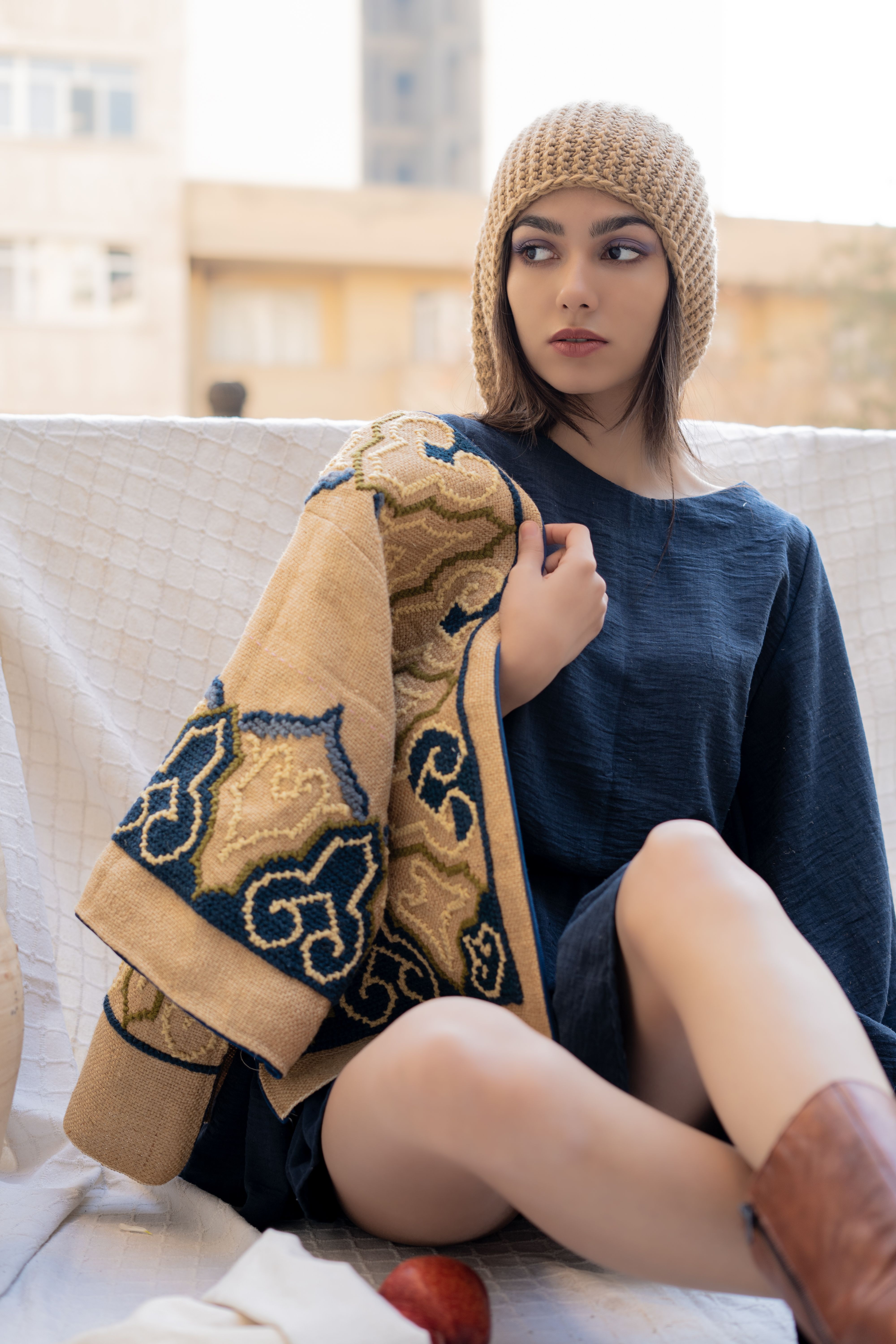 Fashionable young woman in Tehran sitting outdoors with stylish attire. Perfect blend of modern and traditional fashion.