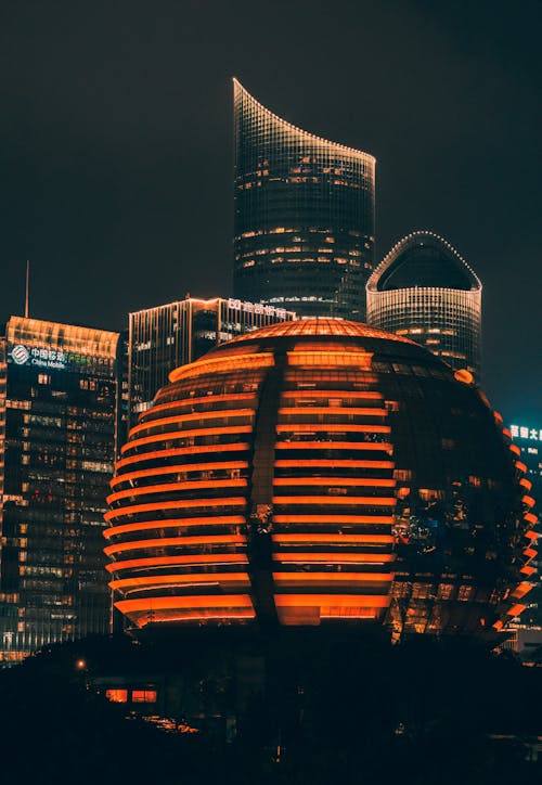 The city of shanghai at night with a large orange sphere