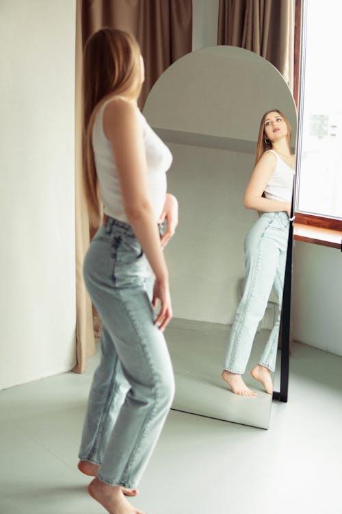 A woman is standing in front of a mirror