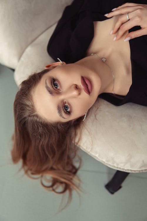 A woman laying on a white couch with her eyes closed