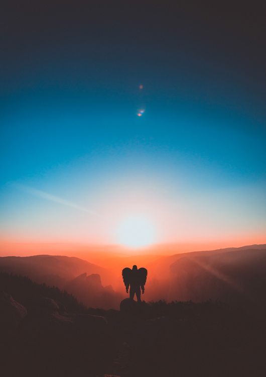 Free A mesmerizing sunset with silhouette of a person with wings, capturing a serene and ethereal moment. Stock Photo