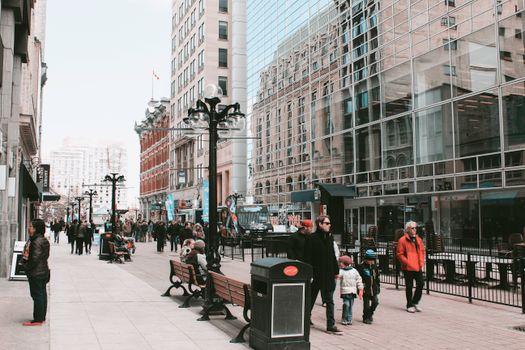 Street view of pedestrians in a bustling urban area with modern architecture.