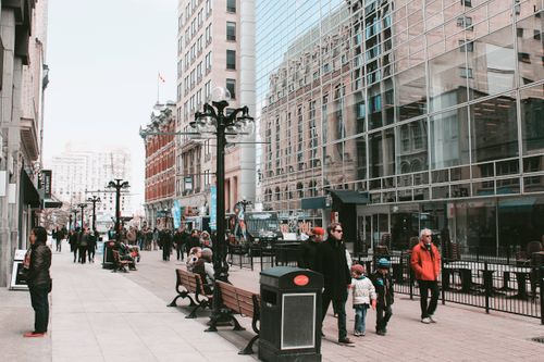 Free Street view of pedestrians in a bustling urban area with modern architecture. Stock Photo