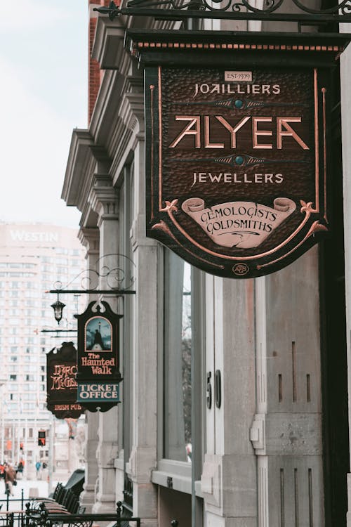 A sign for ayer's jewelry store hangs on a building