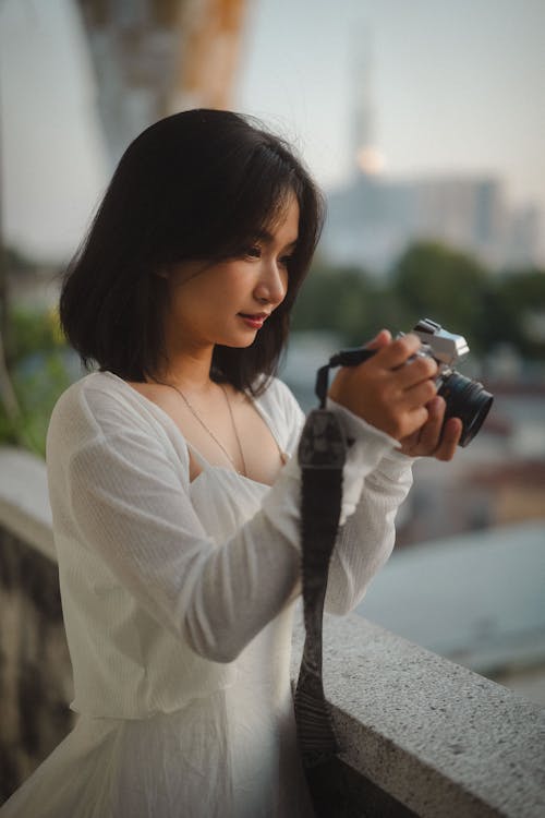 Kostnadsfri bild av asiatisk kvinna, håller, kamera