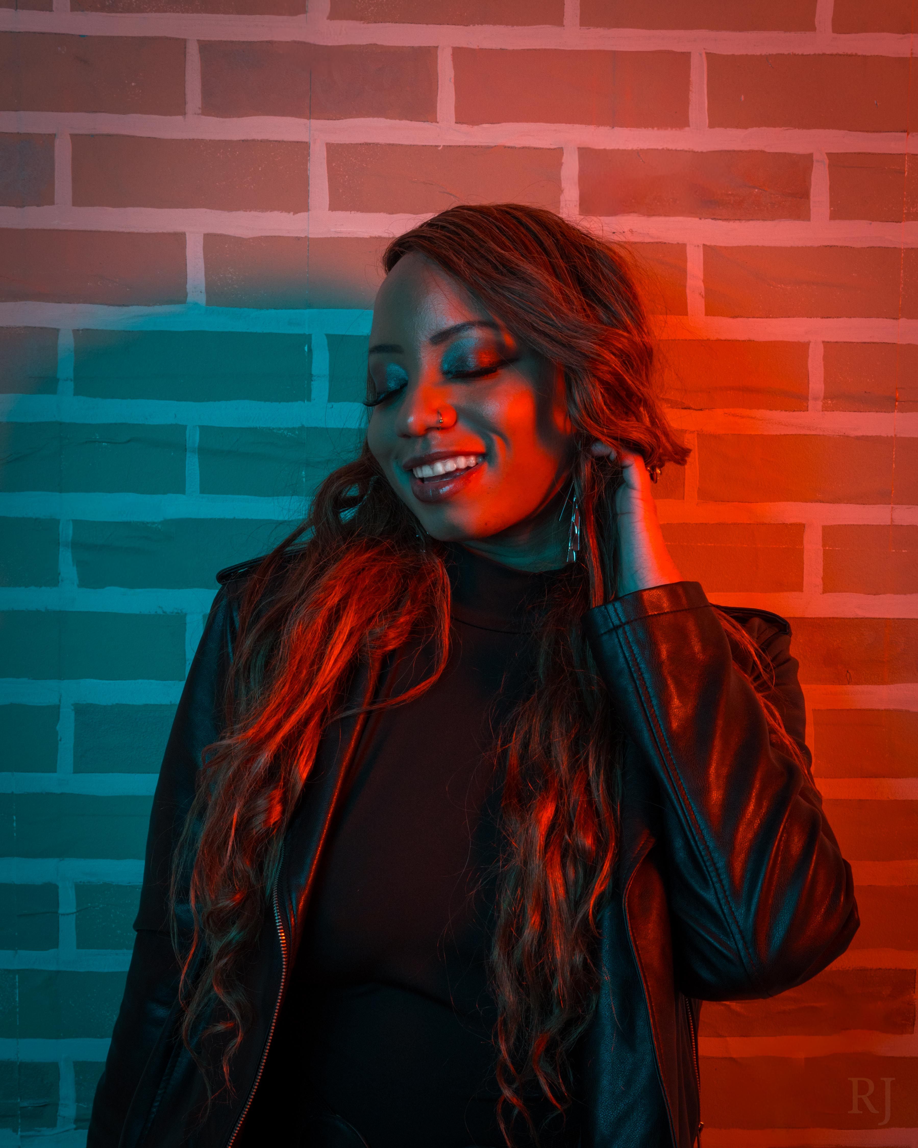 Portrait of a woman in black jacket with red and blue lighting