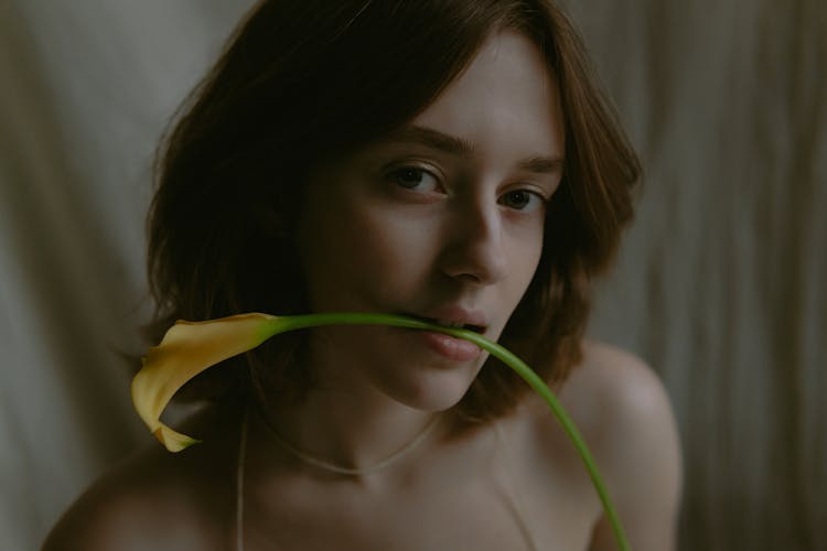 Portrait Of Brunette Woman With Orange Flower 