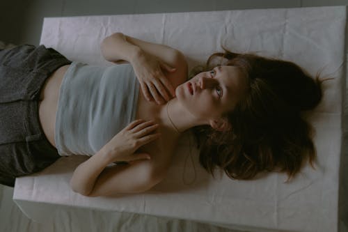 A woman laying on a bed with her eyes closed