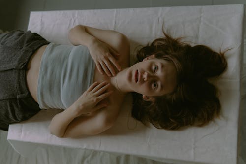 A woman laying on a bed with her head down