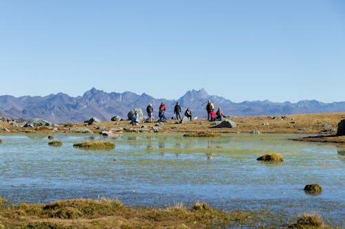 People Hiking by Lake in Countryside