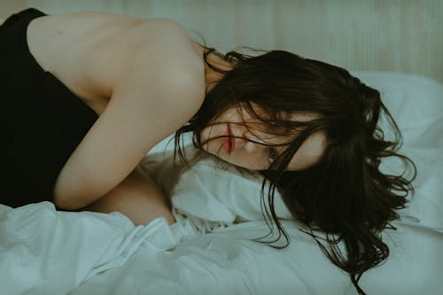 A woman laying on a bed with her hair in her face