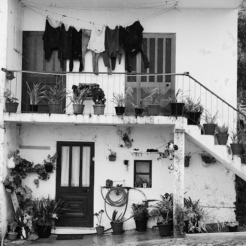 Black and white photograph of a house with clothes hanging on the balcony